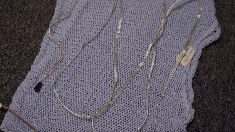 Placing sweater inside out and stitching LED controller for wearable project